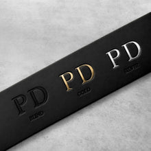 Load image into Gallery viewer, Personalised black full-grain leather belt with blind, gold and silver foil debossed initials on a black leather strap
