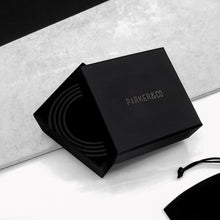 Load image into Gallery viewer, Men’s black branded ‘PARKER&amp;CO’ gift box packaging with the lid half open, revealing a spiralled belt inside, on a grey and white stone surface.
