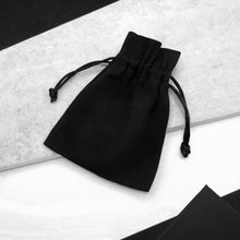 Load image into Gallery viewer, Black cotton drawstring pouch on a light grey stone surface