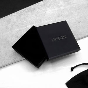 Black Parker & Co. gift box with minimalist branding, styled on a modern monochrome background.