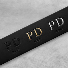 Load image into Gallery viewer, A close-up of a black rectangular product box or packaging with embossed and metallic lettering reading PD, with color variants labeled BLIND, GOLD, and SILVER on a light gray textured background.